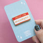 Hello On A Sidequest enamel pin name badge on backing card